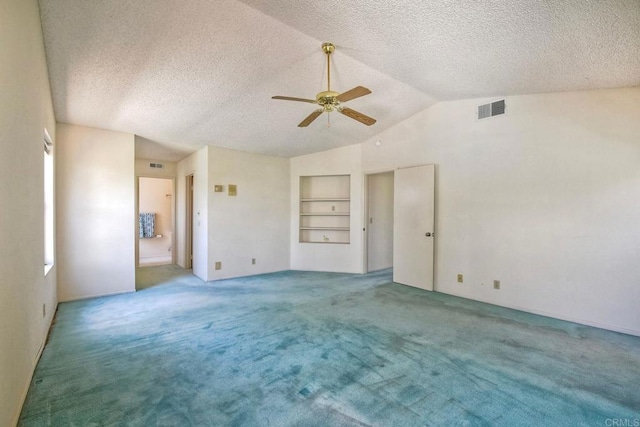 carpeted empty room featuring lofted ceiling, a textured ceiling, visible vents, built in features, and a ceiling fan