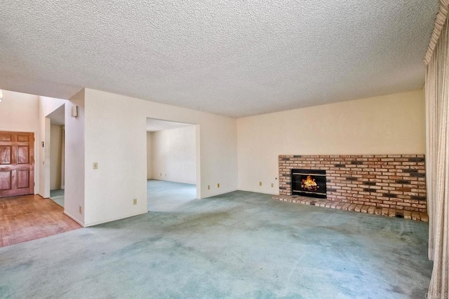 unfurnished living room with carpet flooring, a fireplace, and a textured ceiling