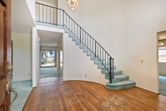 entrance foyer featuring stairs, a healthy amount of sunlight, and wood finished floors