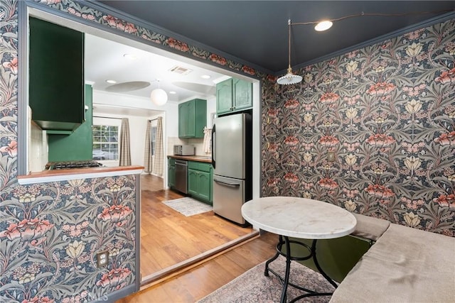 6338 Court Ave, Whittier, CA 90601 - kitchen with green cabinets, visible vents, crown molding, light wood-style floors, and stainless steel appliances