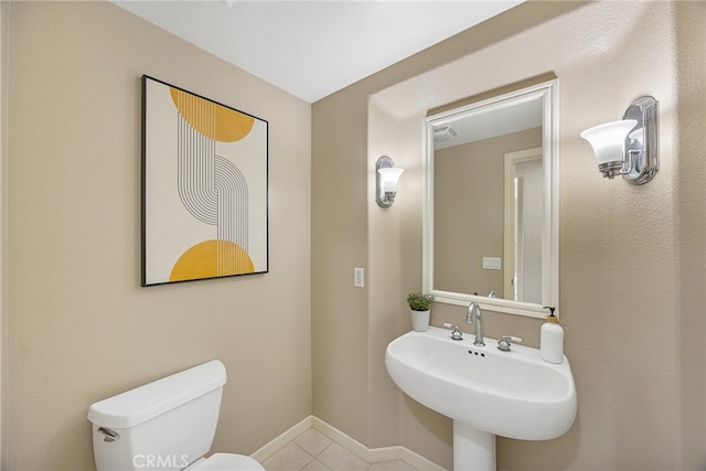 bathroom featuring a sink, tile patterned flooring, toilet, and baseboards
