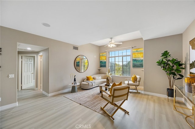 living room featuring baseboards, ceiling fan, visible vents, and light wood-type flooring