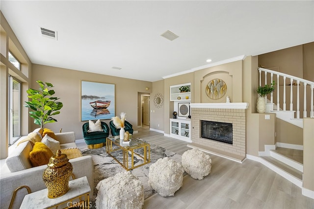 living area with baseboards, stairs, visible vents, and wood finished floors