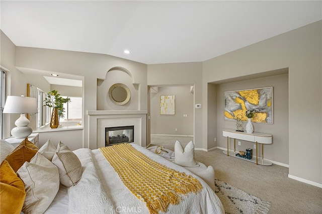 bedroom with recessed lighting, baseboards, a glass covered fireplace, vaulted ceiling, and carpet floors