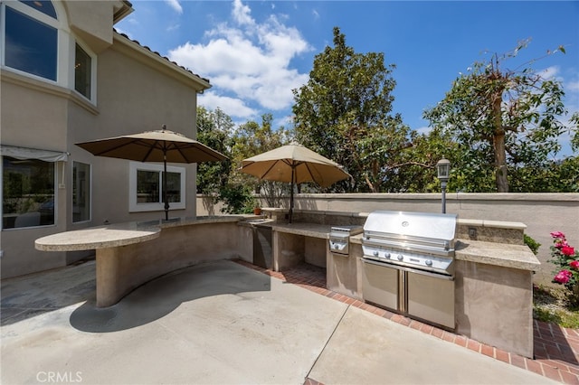 view of patio / terrace featuring exterior kitchen and a grill