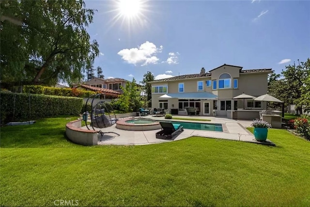 back of property featuring a yard, an in ground hot tub, a fenced in pool, and a patio