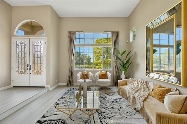 sitting room featuring french doors, wood finished floors, and baseboards