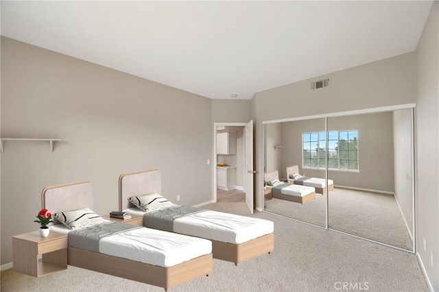 bedroom featuring baseboards, a closet, visible vents, and light colored carpet