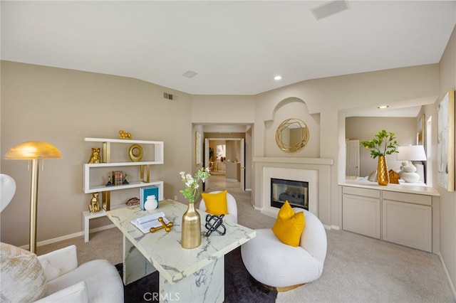 living room with recessed lighting, a high end fireplace, visible vents, and light colored carpet