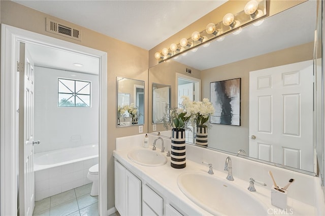 full bathroom featuring a sink, tiled tub, visible vents, and tile patterned floors