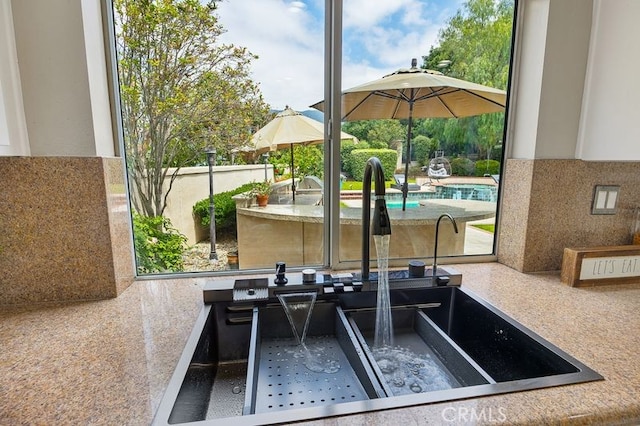 exterior space featuring an outdoor pool and a sink