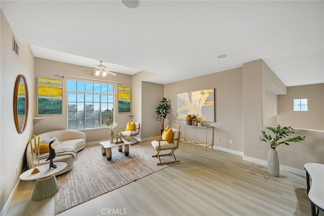 living area with visible vents, wood finished floors, and a healthy amount of sunlight