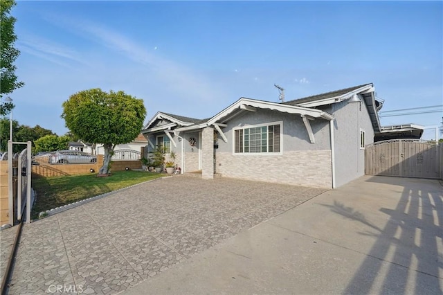 view of front facade with a gate, fence, stucco siding, and a front yard