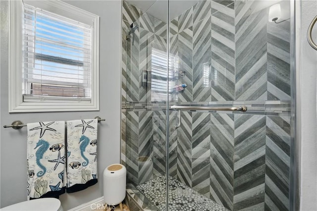 bathroom featuring toilet and a shower stall