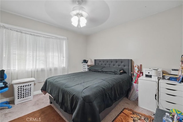carpeted bedroom with a ceiling fan and baseboards