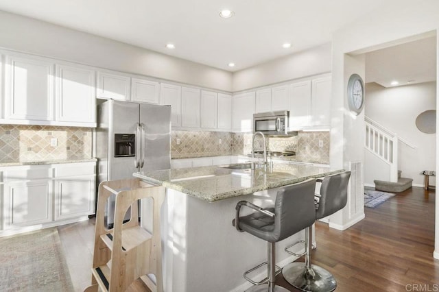 18562 Caminito Pasadero, San Diego, CA 92128 - kitchen with white cabinetry, appliances with stainless steel finishes, light stone counters, and a sink