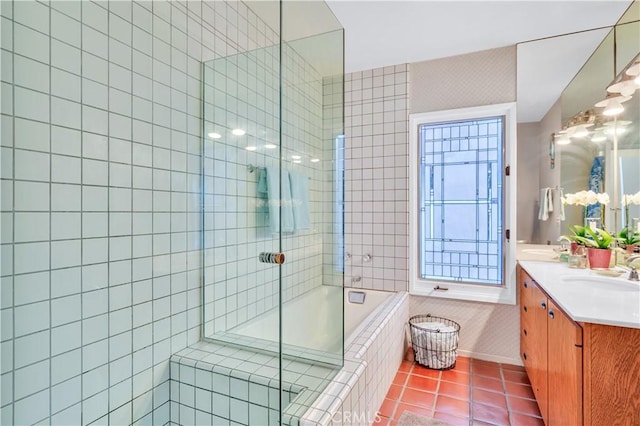 bathroom with a relaxing tiled tub, a sink, tiled shower, tile patterned floors, and double vanity