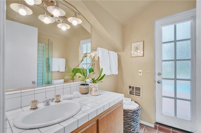 full bath with a shower with door, vanity, baseboards, and tile patterned flooring
