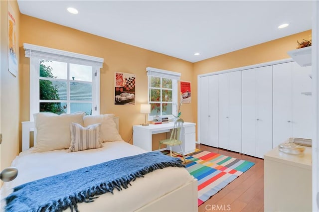 bedroom with a closet, wood finished floors, and recessed lighting