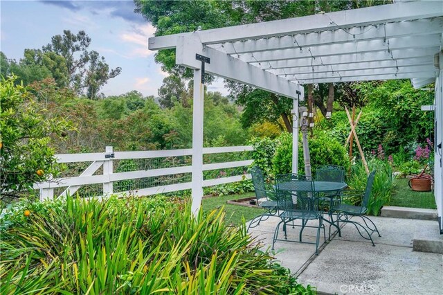 view of patio / terrace with outdoor dining space, a pergola, and fence