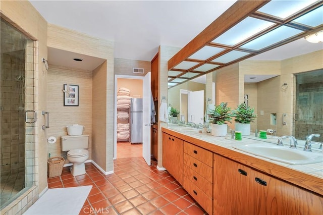 full bathroom featuring toilet, visible vents, a sink, a shower stall, and tile patterned floors