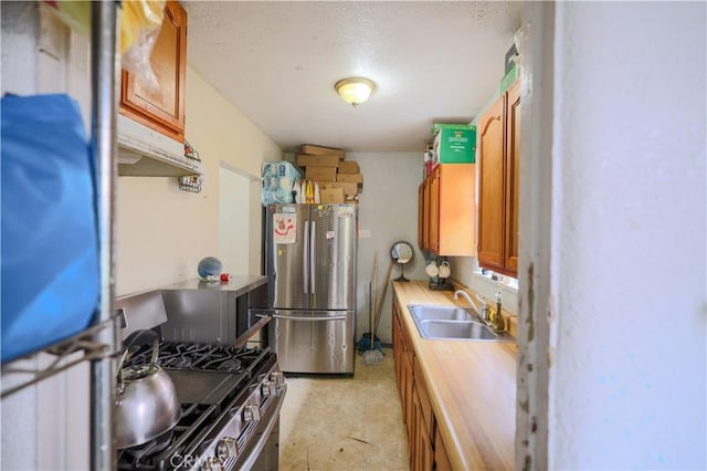 1341 N Fries, Wilmington, CA 90744 - kitchen featuring a sink, brown cabinetry, stainless steel appliances, a textured ceiling, and under cabinet range hood