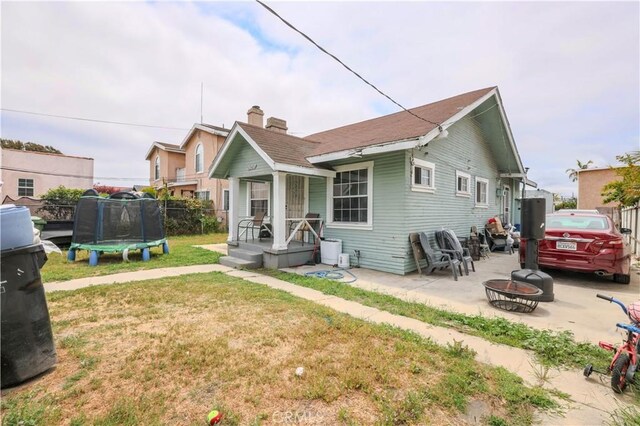 1341 N Fries, Wilmington, CA 90744 - back of house with a lawn, fence, a patio, an outdoor fire pit, and a trampoline