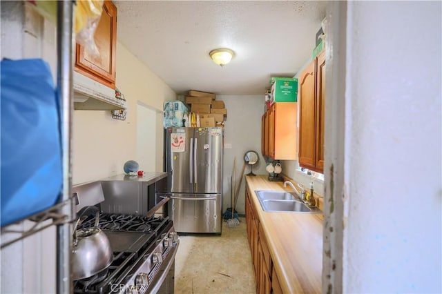 1341 N Fries, Wilmington, CA 90744 - kitchen featuring a sink, brown cabinets, a textured ceiling, under cabinet range hood, and appliances with stainless steel finishes