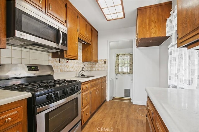 4441 W 145th, Lawndale, CA 90260 - kitchen with stainless steel appliances, brown cabinets, a sink, and light countertops