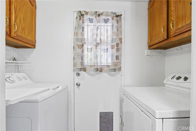 clothes washing area featuring cabinet space and washing machine and dryer