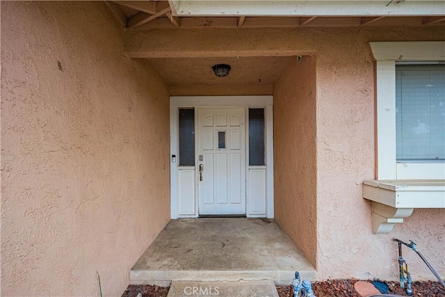 entrance to property featuring stucco siding