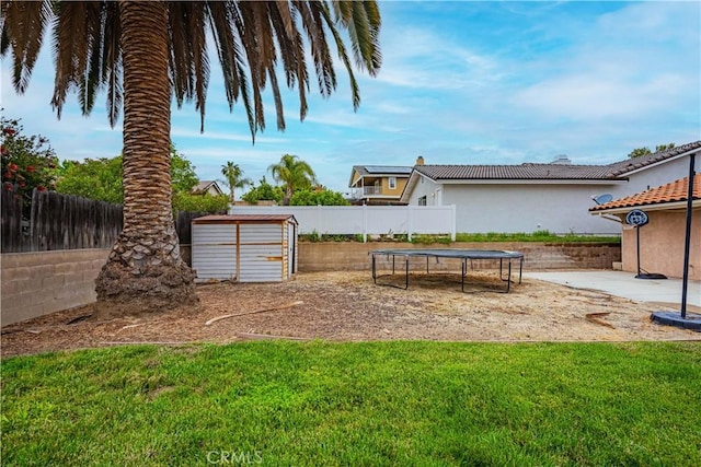view of yard featuring a trampoline and a fenced backyard