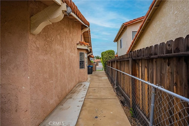 view of home's exterior with fence, stucco siding, and a tiled roof