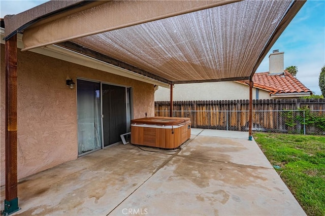 view of patio / terrace with a hot tub and a fenced backyard