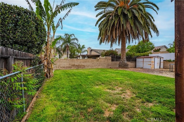 view of yard featuring a fenced backyard, a storage unit, and an outbuilding