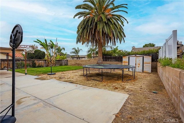 exterior space featuring a trampoline, an outdoor structure, a fenced backyard, and a storage unit