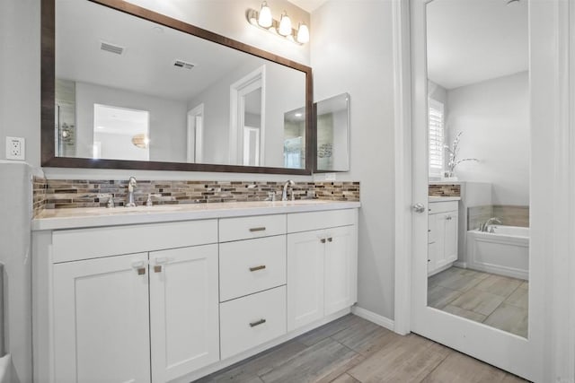 full bath with a sink, double vanity, and visible vents
