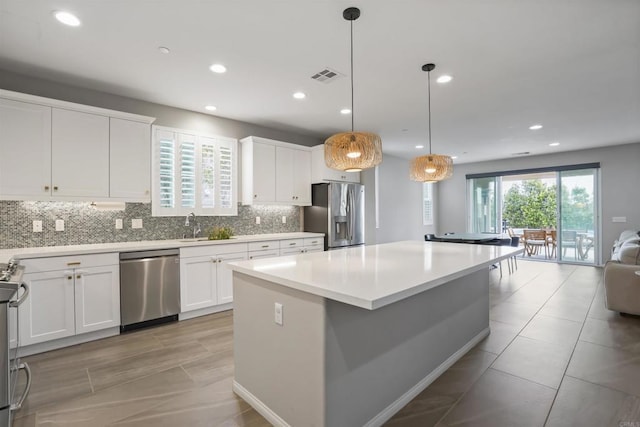 kitchen with a center island, open floor plan, visible vents, appliances with stainless steel finishes, and tasteful backsplash
