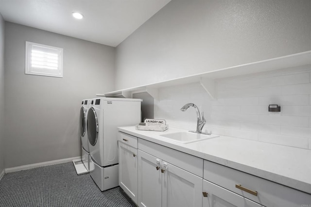 washroom with recessed lighting, baseboards, washer and dryer, a sink, and cabinet space