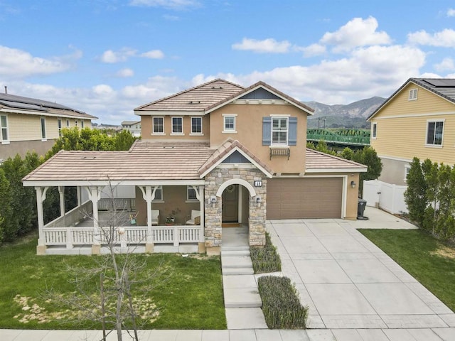 view of front of property with driveway, a tiled roof, fence, stucco siding, and a porch