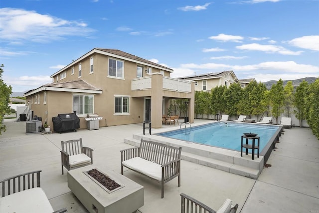 view of swimming pool featuring a grill, a patio, a fenced in pool, central AC unit, and an outdoor living space with a fire pit