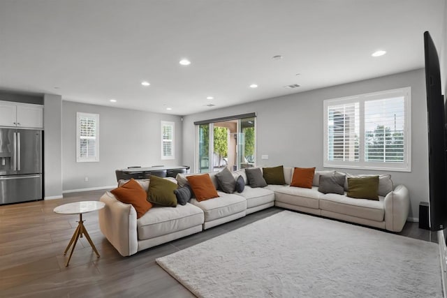 living area featuring recessed lighting, baseboards, and wood finished floors