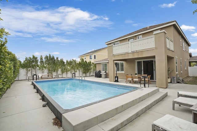view of pool with a patio area, outdoor dining space, a fenced backyard, and a fenced in pool