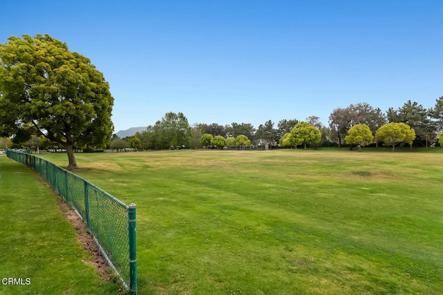 view of home's community with a mountain view and fence