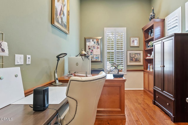 office space with baseboards and light wood-style floors
