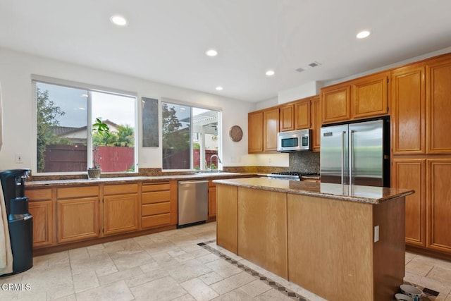 kitchen featuring a center island, a wealth of natural light, stainless steel appliances, and a sink