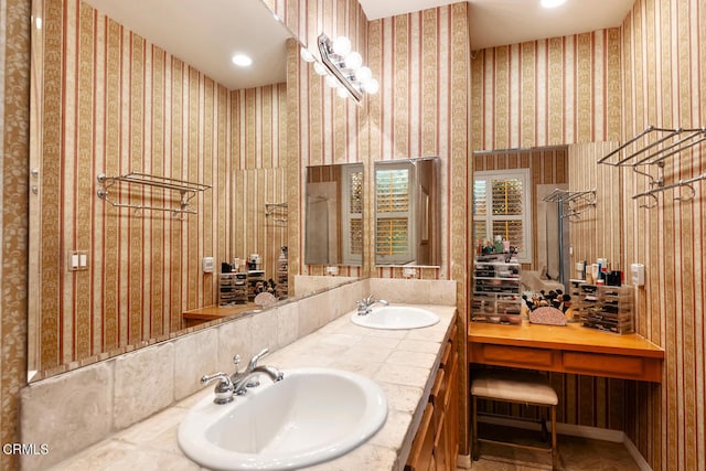 bathroom with a sink, double vanity, and wallpapered walls