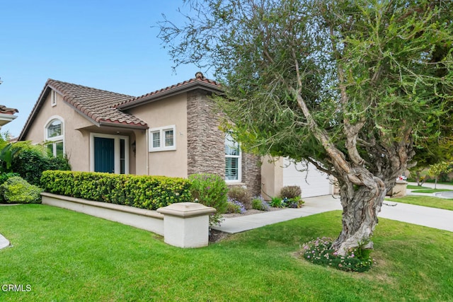 view of front of home featuring stucco siding, a front lawn, stone siding, and driveway