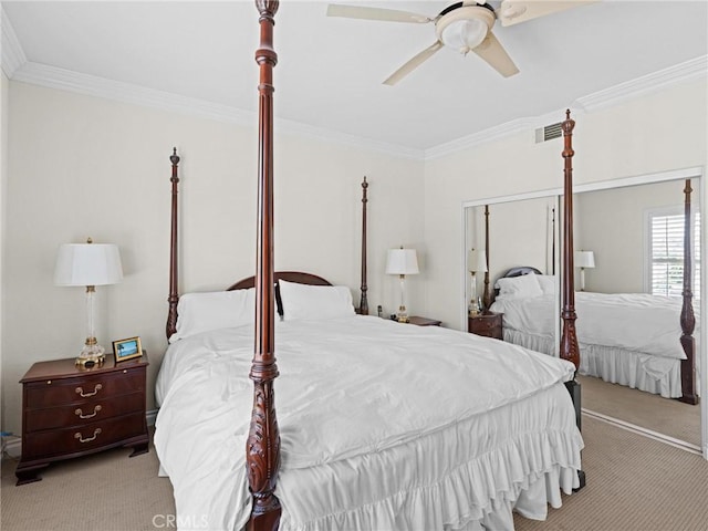 carpeted bedroom with ornamental molding and a ceiling fan