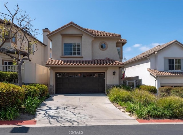 mediterranean / spanish-style house featuring a garage, concrete driveway, stucco siding, and a tile roof